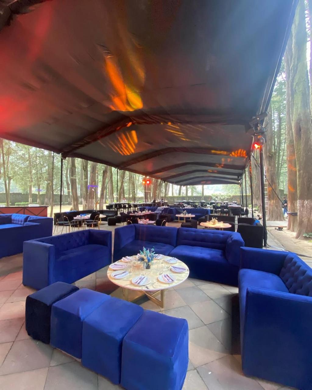 Lounge azul con mesas de coctel