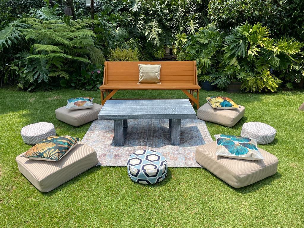 Sala de jardín con cojines para descanso